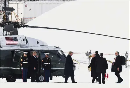  ?? — AP ?? Wintry welcome: Trump (centre) arriving in Davos for the World Economic Forum.