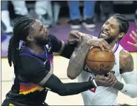  ??  ?? Clippers guard Paul George, right, is stopped in the lane by Suns forward Jae Crowder during the second half of Game 1of the Western Conference finals on Sunday in Phoenix.