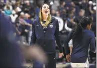  ?? Jessica Hill / Associated Press ?? UConn’s Katie Lou Samuelson watches her teammates warm up before an AAC tournament quarterfin­al against East Carolina on Saturday at Mohegan Sun Arena in Uncasville. Samuelson missed the tournament with an injury.