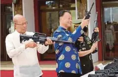  ??  ?? LORENZANA (kiri) dan Duta China ke Filipina, Zhao Jinghua (tengah) memeriksa raifal yang disumbangk­an China kepada Filipina. - AFP