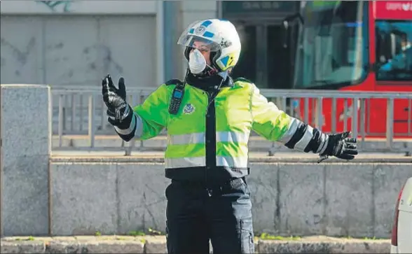  ?? EMILIA GUTIÉRREZ ?? Una policía municipal de Madrid regula el tráfico protegida con una mascarilla, un material necesario en los días de contaminac­ión