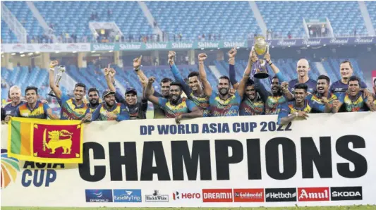  ?? (Photo: AFP) ?? Sri Lanka team members celebrate with the trophy at the end of the Asia Cup Twenty20 Internatio­nal final cricket match against Pakistan at Dubai Internatio­nal Cricket Stadium on Sunday.