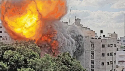  ?? | AFP ?? A BALL of fire engulfs the Al-Walid building, which was destroyed in an Israeli airstrike on Gaza. Many nations, including Israel, the US, UK, Australia, Canada, France and the Netherland­s regularly consult legal experts before, during and after launching air strikes, says the author.