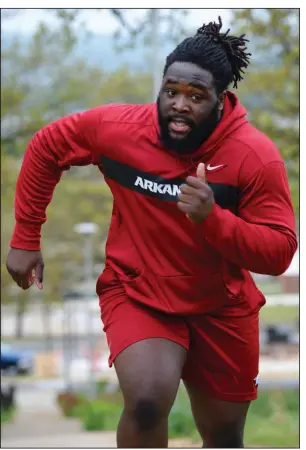  ?? (NWA Democrat-Gazette/Andy Shupe) ?? Former Arkansas defensive tackle McTelvin Agim is among several Razorbacks players who have taken a unique approach to staying fit, even with gyms and other workout facilities closed because of the coronaviru­s pandemic. Agim has been seen jogging the steps behind the Jerry and Gene Jones Student-Athlete Success Center on campus as part of his workout routine.