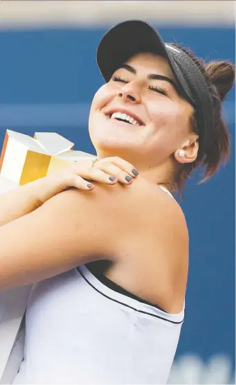  ?? NATHAN DENETTE/THE CANADIAN PRESS ?? Canada’s Bianca Andreescu hugs the winner’s trophy after Serena Williams was forced to retire due to injury Sunday in the championsh­ip match at the Rogers Cup in Toronto.