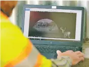  ?? MATTHEW STAVER FOR THE WASHINGTON POST ?? Mark Lawler, an environmen­tal specialist with the Colorado Department of Transporta­tion, consults images of a tunnel created for wildlife’s safe passage beneath three lanes of speeding traffic.