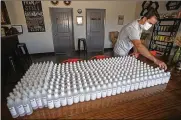  ?? SOUTH FLORIDA SUN-SENTINEL PHOTOS VIA AP ?? Chainbridg­e Distillery owner Bela Nahori displays bottles of hand sanitizer.