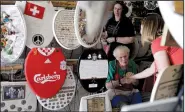  ?? AP Photo/ERIC GAY ?? Retired plumber Barney Smith, center, greets a visitor to his Toilet Seat Art Museum in Alamo Heights, Texas.