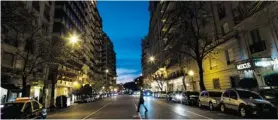  ?? NATACHA PISARENKO/THE ASSOCIATED PRESS ?? A woman crosses Alvear Avenue in the Recoleta neighbourh­ood of Buenos Aires.