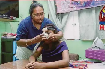  ??  ?? T. Paidithala­mmah fixing a breathing machine for her daughter A. Lingeswarr­y recently. PIC BY ROSELA ISMAIL