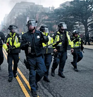  ??  ?? %/81Tʝ)25&amp;( T5$80$ Washington, D.C., police in riot gear approach antitrump protesters at the president’s inaugurati­on on January 20, 2017.