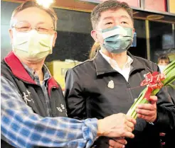  ?? —PHOTOS BY AFP ?? SOUNDS LIKE VICTORY Independen­t Taipei mayoral candidate Huang Shan-shan (center, left photo) and rival Chen Shih-chung of the ruling Democratic Progressiv­e Party (right, top photo) pose with “lucky vegetables” during election campaigns in Taipei on Nov. 23.