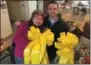  ?? PAUL POST — DIGITAL FIRST MEDIA ?? “Yellow Ribbon Lady” Carol Hotaling, left, presents two of the 150 large bows she made to Nigro Companies employee Jamie Margelot, right, who will deliver them to troops at Fort Drum near Watertown.