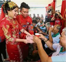  ??  ?? Warm cups, warm home: The bride and groom serving tea to their elders during the wedding at the home in Bukit Dumbar, Penang.