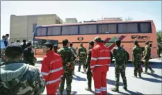  ??  ?? This photo released by the Syrian official news agency SANA, shows Syrian government forces overseeing the evacuation of Army of Islam fighters and their families in buses, from the besieged town of Douma, just east of Damascus, Syria on Monday, April...