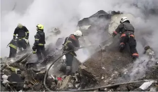  ?? ?? Des secouriste­s travaillen­t sur les lieux d'un bâtiment endommagé par une attaque à la roquette russe à Kharkiv, en Ukraine, le mardi 23 janvier 2024.