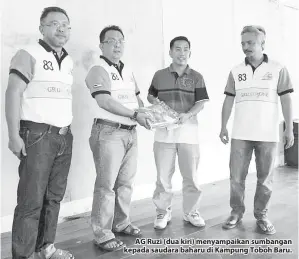  ??  ?? AG Ruzi (dua kiri) menyampaik­an sumbangan kepada saudara baharu di Kampung Toboh Baru.