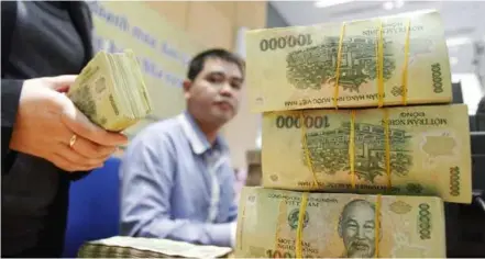  ?? VNA/VNS Photo ?? Vietnamese VNĐ100,000 banknotes at a bank.