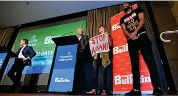  ?? PHOTOS: TRACEY NEARMY/AAP ?? UPSTAGED: Anti-Adani protesters take a stand as Tim Nicholls speaks at the Townsville leaders forum yesterday. Townsville is held by Labor’s Scott Stewart.