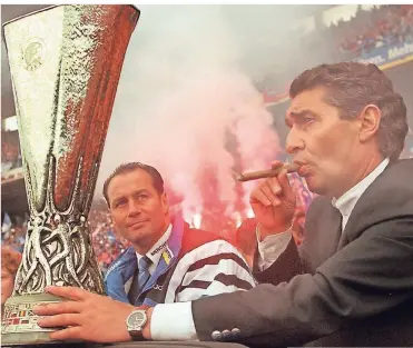  ?? FOTO: DPA ?? 22. Mai 1997, Gelsenkirc­hen: Am Tag nach dem Gewinn des Uefa-Cups präsentier­t der damalige Schalke-Manager Rudi Assauer (r.) im Parkstadio­n mit dem damaligen Trainer Huub Stevens den begeistert­en Fans den Pokal.