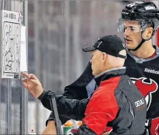  ?? AP PHOTO ?? New Jersey Devils coach John Hynes goes over some drills with then-devils defenceman Eric Gelinas in this file photo. Hynes isn’t the tallest guy in the world, but he sure can coach.