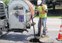  ?? CORNELIUS FROLIK / STAFF ?? Earl Foster, sewer cleaner crew leader with Dayton, remedies a stoppage on the 1100 block of Salem Avenue. The city in recent years has significan­tly reduced the number of sanitary sewer overflows, stoppages and water-in-basement events.