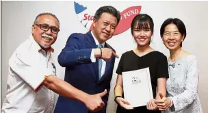  ??  ?? Well-deserved recipient: (From left) Dr Adnan, Wong, Adeline and Lim posing after the Star Education Fund ceremony at the Eastin Hotel in Petaling Jaya.