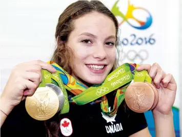  ?? RYAN REMIORZ/THE CANADIAN PRESS ?? Canada’s Penny Oleksiak, from Toronto, holds up her four medals, a gold, silver and two bronze, she won at the 2016 Summer Olympics during a 2016 news conference in Rio de Janeiro, Brazil. Oleksiak is the winner of the Lou Marsh Trophy as Canada’s...