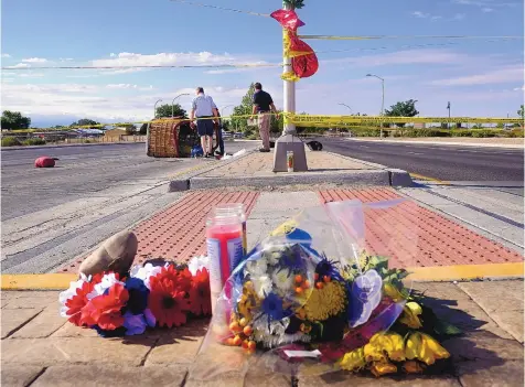  ?? ADOLPHE PIERRE-LOUIS/JOURNAL ?? Flowers and candles left by mourners Sunday near the scene of a balloon crash Saturday that killed five. Investigat­ors with the National Transporta­tion Safety Board inspect the balloon gondola in the background.