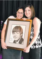  ?? PHOTO COURTOISIE CHRISTELLE BILODEAU ?? Christelle Bilodeau et Manon Tremblay arborant fièrement le portrait signé de Paul Mccartney dessiné par Christelle.