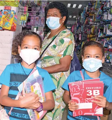  ?? Photo: Ronald Kumar ?? Twin sisters eight year-old’s Leba Rosie and Esther Kuini with their grandmothe­r, Leba Ravula while shopping for their back to school shopping on December 31, 2021.