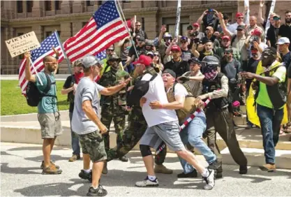  ??  ?? TEXAS: Kyle Chapman, president of the Texas Alt-Knights, is held back by his fellow Trump supporters from confrontin­g Trump protester Nevin Kamath (far left) at the impeachmen­t march at the Capitol in Austin, Texas, on Sunday July 2, 2017. Kamath tried...