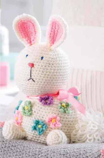  ??  ?? With her cute, whimsical expression, this sweet bunny will delight your little ones when they find her nestled in their Easter basket! Simple to crochet in worsted-weight yarn using basic stitches, you’ll want to make several to give as gifts!