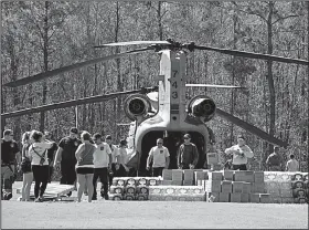  ?? AP/The Star-News/KEN BLEVINS ?? A National Guard Chinook helicopter drops off supplies Wednesday at hard-hit Town Creek, N.C., as relief efforts continue in the aftermath of Hurricane Florence.