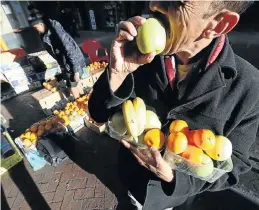  ?? Picture: Esa Alexander ?? A man eats an apple he bought from a hawker in Cape Town’s CBD. Produce at the Cape Town market in Epping has not been tested for pesticides for about five years.