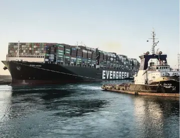  ?? DPA/Zuma Press/TNS ?? A tugboat drags the Ever Given in the Suez Canal after the ship was freed and re-floated on Monday.