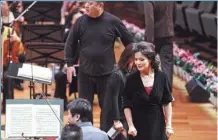  ?? PHOTOS BY JIANG DONG / CHINA DAILY ?? Clockwise from top: The China NCPA Orchestra holds a ceremony to mark its 10th anniversar­y after an open rehearsal at the National Center for the Performing Arts in Beijing on Nov 12; music director Lyu Jia (right) works with the orchestra to play Wang Ning (right), director of the NCPA, speaks at the anniversar­y ceremony; soprano Song Yuanming (right) at the rehearsal; and musicians with the orchestra rehearse Beethoven’s work.