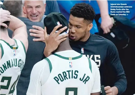  ?? AP ?? Injured star Giannis Antetokoun­mpo embraces Bobby Portis after the Bucks reached the NBA Finals on Saturday.