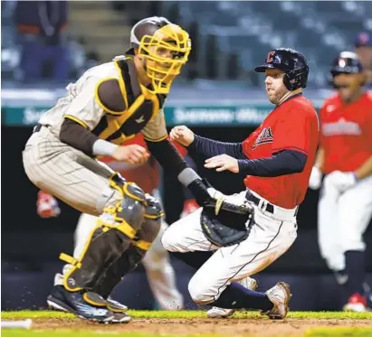  ?? RON SCHWANE AP ?? Cleveland’s Owen Miller scores the winning run past Padres catcher Austin Nola in the 10th inning of the second game.