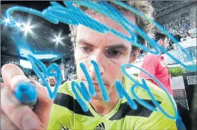  ??  ?? Andy Murray autographs a TV camera in Madrid in May 2014 before adding Elena Baltacha’s nickname of Bally with a heart and a kiss. He was paying tribute to Elena, 30, after her death just days earlier