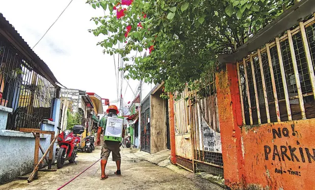  ?? NONIE REYES ?? A MEMBER of the Las Piñas City disinfecti­on team sprays disinfecta­nt on Rosal Street to keep it sanitized as part of measures to curb the spread of the coronaviru­s. Metro Manila will remain under modified enhanced community quarantine until September 7, 2021.