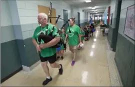  ?? MATHEW MCCARTHY, RECORD STAFF ?? Kieran McPate, the custodian at St. Agatha Catholic school, leads the students out of the school on Friday, before it was closed for good. Students walked out of the building in single file, youngest to oldest. Most were wearing the bright green school...