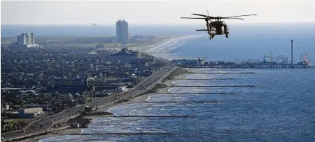  ?? Michael Ciaglo / Staff file photo ?? An Army Black Hawk helicopter carrying Army Corps of Engineers officials flies over Galveston in 2016 while on a tour of the Corps’ current and proposed projects, including the “Ike Dike” coastal barrier system.