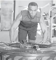  ?? Elizabeth Conley photos / Houston Chronicle ?? Fox 26 anchor Jonathan Martin pushes a 275-pound tire at O Athletik in the Heights.