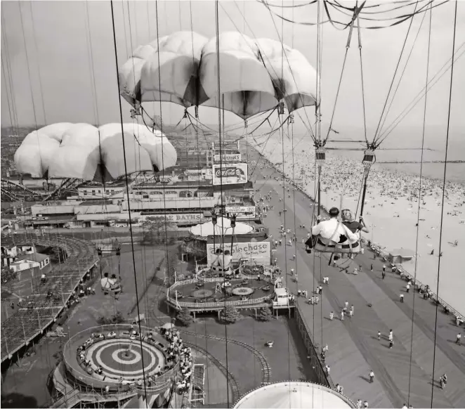 ??  ?? PARACHUTE RIDES bring couples close together as they rise, then drop, over Steeplecha­se Park in 1954.