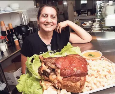  ?? Arnold Gold / Hearst Connecticu­t Media ?? Rosario Castro, co-owner of El Rincon Del Sabor Latin Restaurant, with a tray of roast pork, white corn and hot sauce at the new Ecuadorian eatery in Westbrook.