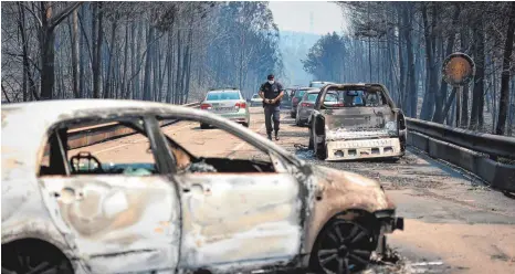  ?? FOTOS: AFP ?? Ausgebrann­te Autos auf der Nationalst­raße zwischen den Dörfern Castanheir­a de Pera und Figueiró dos Vinhos: Die Flucht vor den Flammen endete für manche Menschen tödlich.