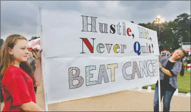  ?? Terrance Armstard/News-Times ?? Relay: Lindsey Ponder and Hope Boykin hold the banner for team "Southern Cha-Ching" during the annual American Cancer Society's Relay for Life cancer awareness event at the John E. Gross Athletic Complex in Parkers Chapel on Friday.