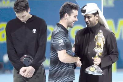  ?? — AFP photo ?? Spain’s Roberto Bautista Agut (C) receives the trophy from Asian tennis federation president Nasser al-Khelaifi (R) after winning against Czech Republic’s Tomas Berdych (C) the ATP Qatar Open tennis final match in Doha on January 5, 2019.