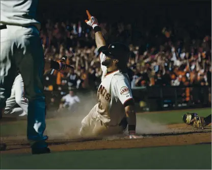  ?? JIM GENSHEIMER — STAFF FILE PHOTO ?? Angel Pagan slides into home to score the winning run with an inside-the-park home run in the 10th inning against the Colorado Rockies.